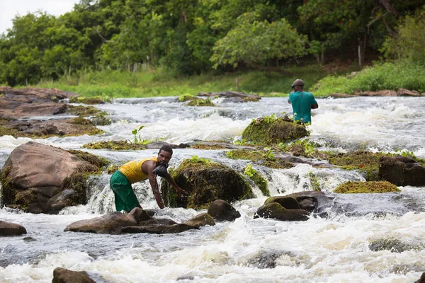 Sert kayalık nehirde balık tutan Afrikalı adamlar, seyahat çekimleri