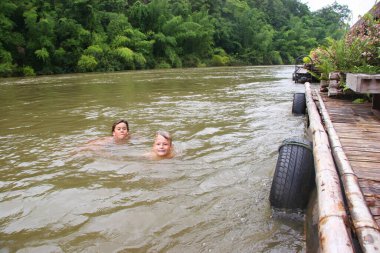 Çocuklar nehirde yüzüyor.