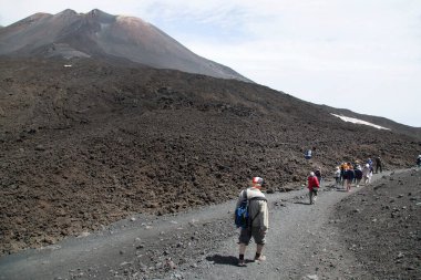 Bir grup turist güzel bir dağ manzarasında yürüyor.