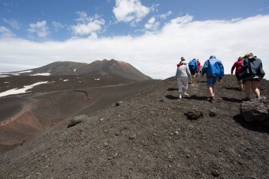 Bir grup turist güzel bir dağ manzarasında yürüyor.