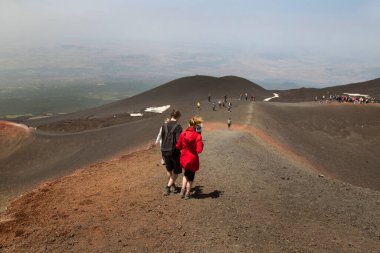 Bir grup turist güzel bir dağ manzarasında yürüyor.