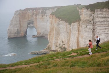 Deniz kıyısında yürüyen turistler
