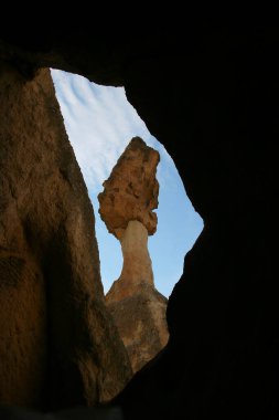 aşınmış peri bacaları ya da çıkıntılar, yukarıda dengelenen daha sert taşlar.