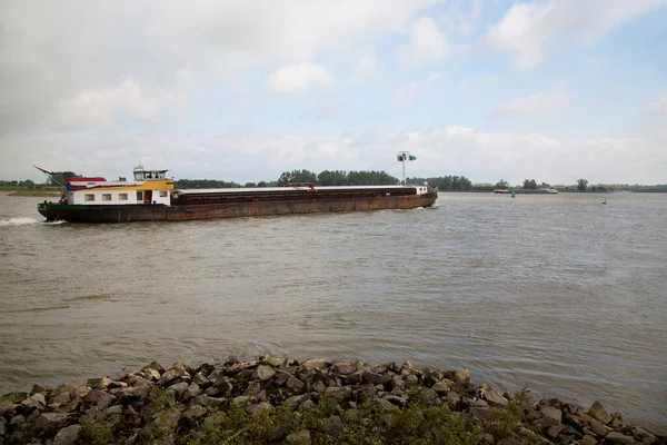 Tekne bulutlu gökyüzünün altında nehirde hareket ediyor