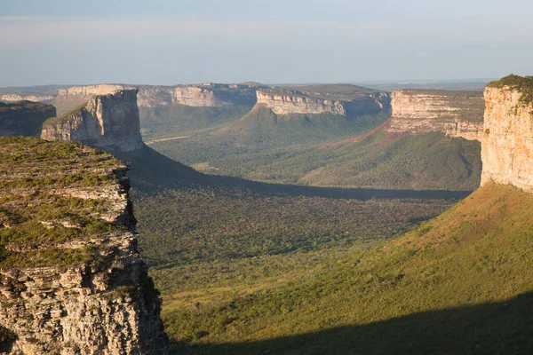 Güneşin yemyeşil olduğu kayalık manzaralı güzel bir manzara.
