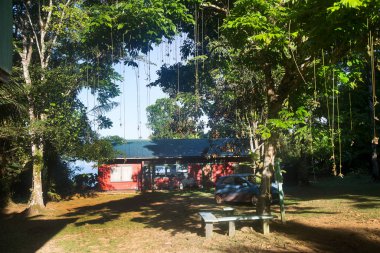 Çayırda park etmiş arabalı ahşap evin manzarası.