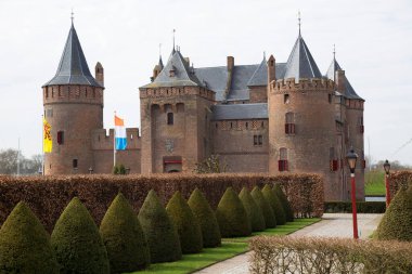 Kırpılmış kayın çitleriyle resmi bahçeli antik bir kale.