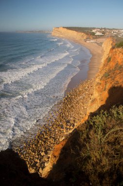 Dalgalar sahildeki kayalara çarpıyor.