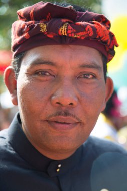 Şenlikli saç bandı takmış Asyalı bir adamın portresi.