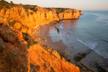 Kayalık deniz kıyısının gün batımı manzarası