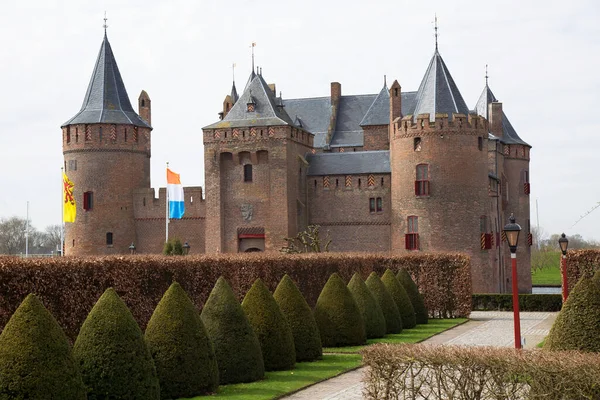 Kırpılmış kayın çitleriyle resmi bahçeli antik bir kale.