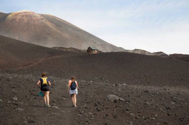 Volkanik tepelerde yürüyen iki kadın manzara, seyahat çekimi