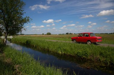 Küçük nehrin yanındaki yolda araba sürmek.