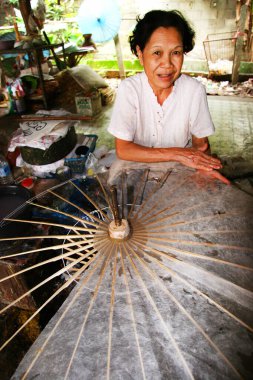 Atölyede yeni şemsiye yapan kadın portresi