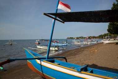 Güneş ışığı, batur gölü ve Endonezya 'da kıyıya demir atmış tekneler.
