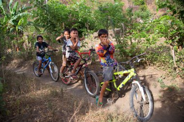 Doğada bisiklet süren mutlu Asyalı çocuklar, seyahat çekimleri.
