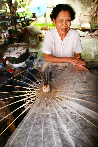 Atölyede yeni şemsiye yapan kadın portresi