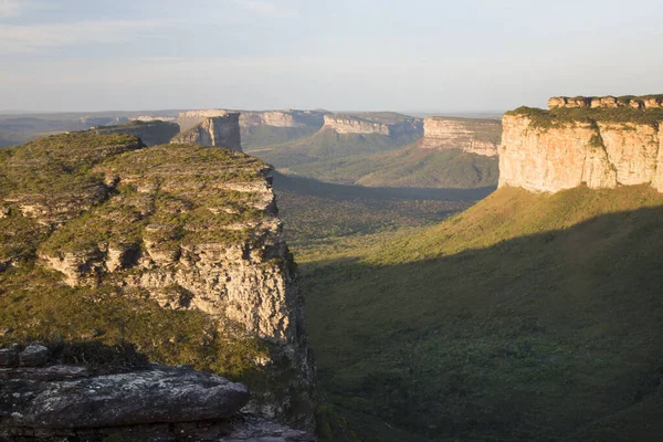 Güneşin yemyeşil olduğu kayalık manzaralı güzel bir manzara.