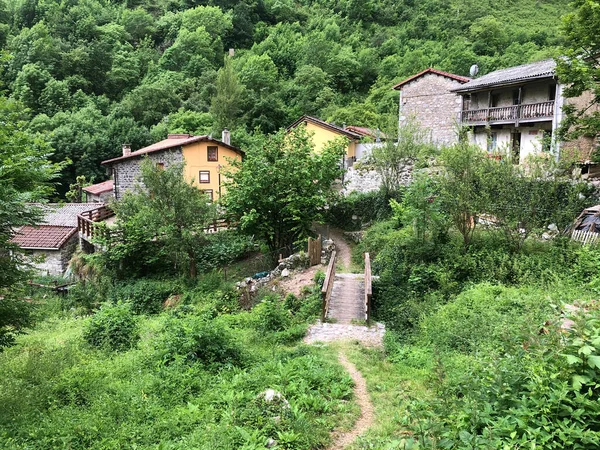 Yüksek dağ zirveleri arasındaki vadideki tipik tarım köyü.