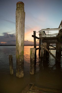 Sahilde gün batımında gökyüzü olan ahşap iskele