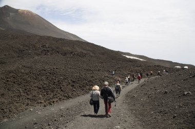 Bir grup turist güzel bir dağ manzarasında yürüyor.