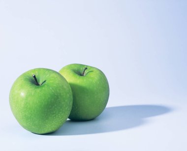 beyaz arkaplanda yeşil elma