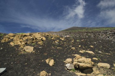 Etna Dağı 'nın krater kenarı lav tarlaları ve dik yamaçlar. Çakıl taşlarıyla kaplı. Güçlü öncü bitkiler tarafından büyütülmüş.