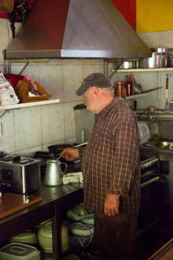 Son sınıf öğrencisi mutfakta yemek pişiriyor. 