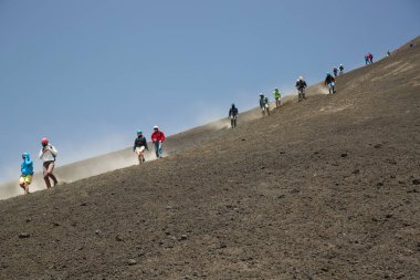 Bir grup turist güzel bir dağ manzarasında yürüyor.