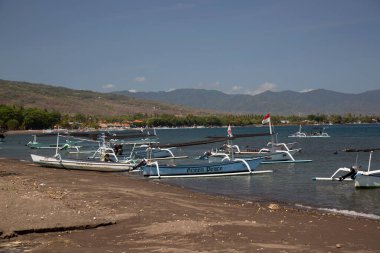 Güneş ışığı, batur gölü ve Endonezya 'da kıyıya demir atmış tekneler.