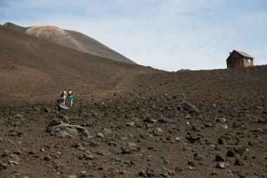 Volkanik tepelerde yürüyen iki kadın manzara, seyahat çekimi