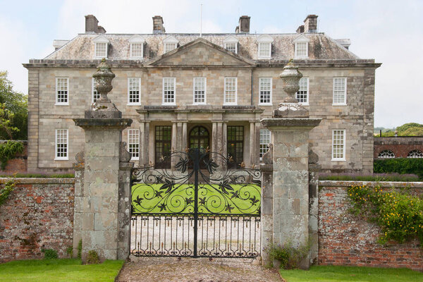 Английский загородный дом в сельской местности с большим лавочником и обширным садом с орнаментами