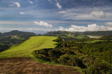 Dağları ve mavi gökyüzü olan güzel bir manzara.