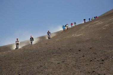 Bir grup turist güzel bir dağ manzarasında yürüyor.