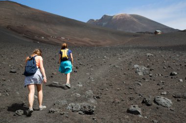 Volkanik tepelerde yürüyen iki kadın manzara, seyahat çekimi