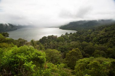 Panoramik krater gölü çevresindeki tepeler yoğun yağmur ormanlarıyla kaplı.