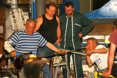 Atölyede çalışan cam üfleyiciler.  