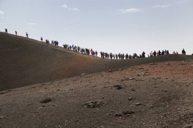 Bir grup turist güzel bir dağ manzarasında yürüyor.