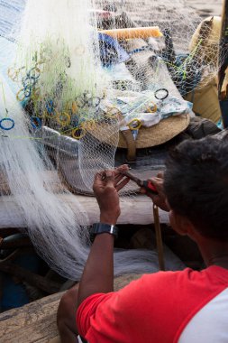 Adam balık ağı kesiyor.