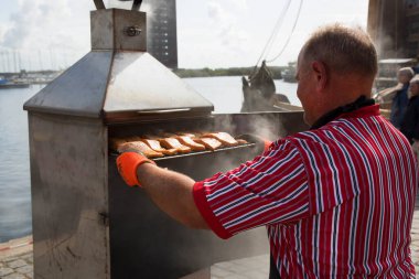 Barajda balık pişiren bir adamın görüntüsü.