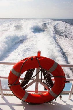 Bir geminin güvertesinde can simidi ve su sıçratan dalgalar
