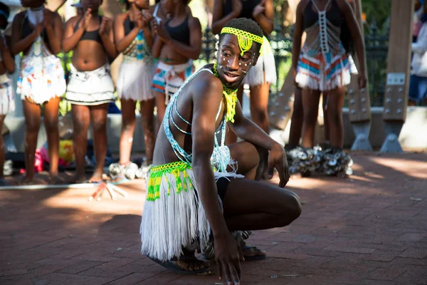 Geleneksel giysiler ve aksesuarlar içinde dans eden Afrikalı bir adam.