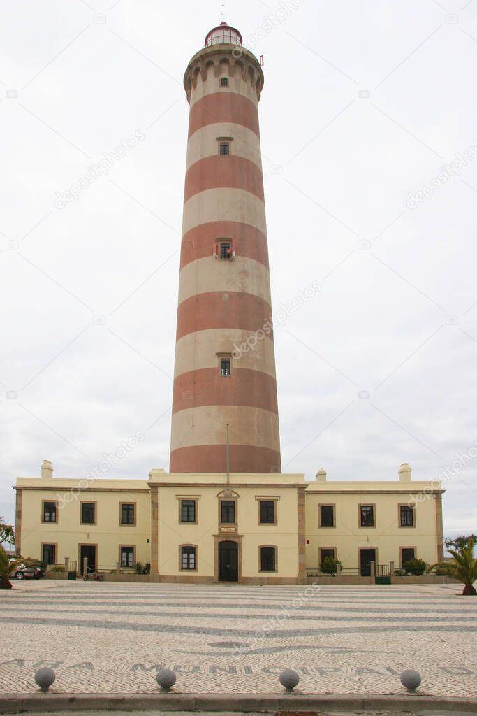 red and white painted lighthouse in coastal city center