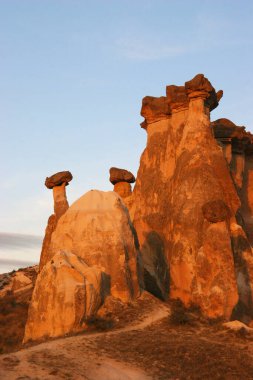 aşınmış peri bacaları ya da çıkıntılar, yukarıda dengelenen daha sert taşlar.