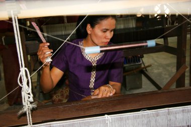 Kumaşta çalışan bir kadın. İpek kumaş üretim konsepti