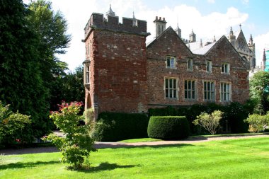 Yeşil ve mavi bulutlu gökyüzü olan eski bir kale binası.