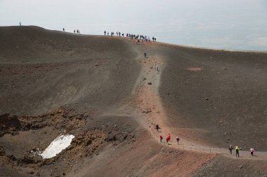 Bir grup turist güzel bir dağ manzarasında yürüyor.