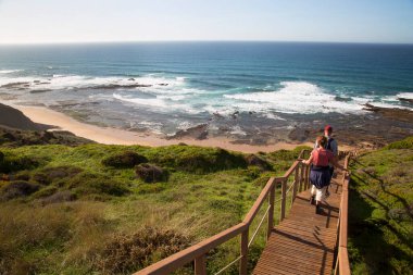 Merdivenlerden deniz kıyısına inen çift.