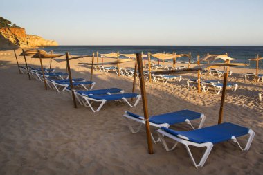 Plastik şezlonglar sahilde sıra sıra dizilmiş.