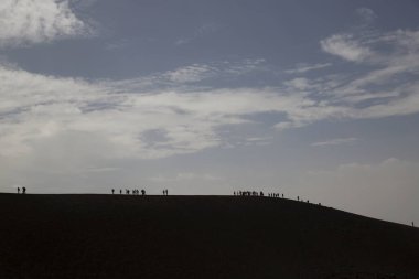Bir grup turist güzel bir dağ manzarasında yürüyor.